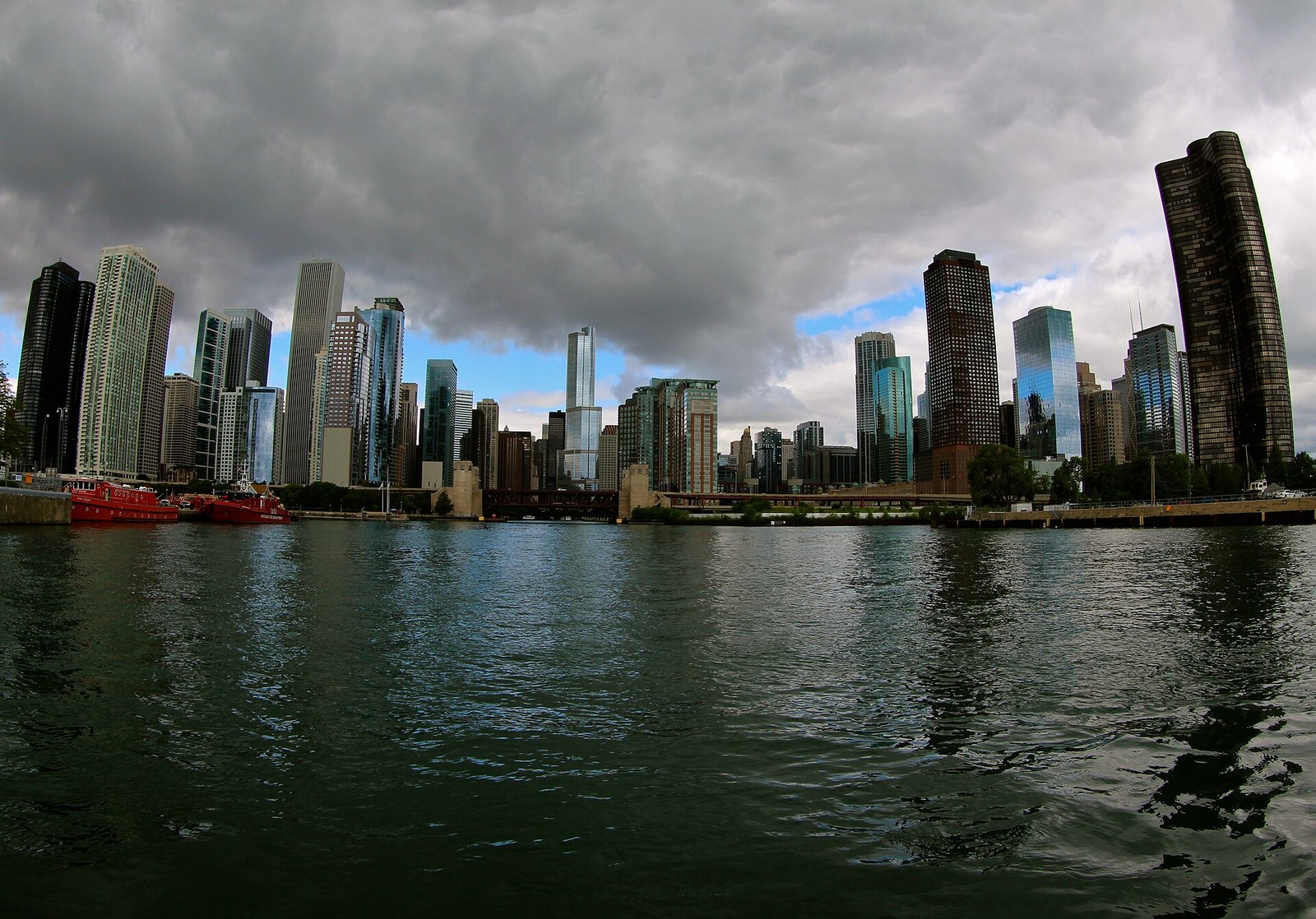 Chicago's lakefront skyline seen from the water beneath a heavy summer sky.