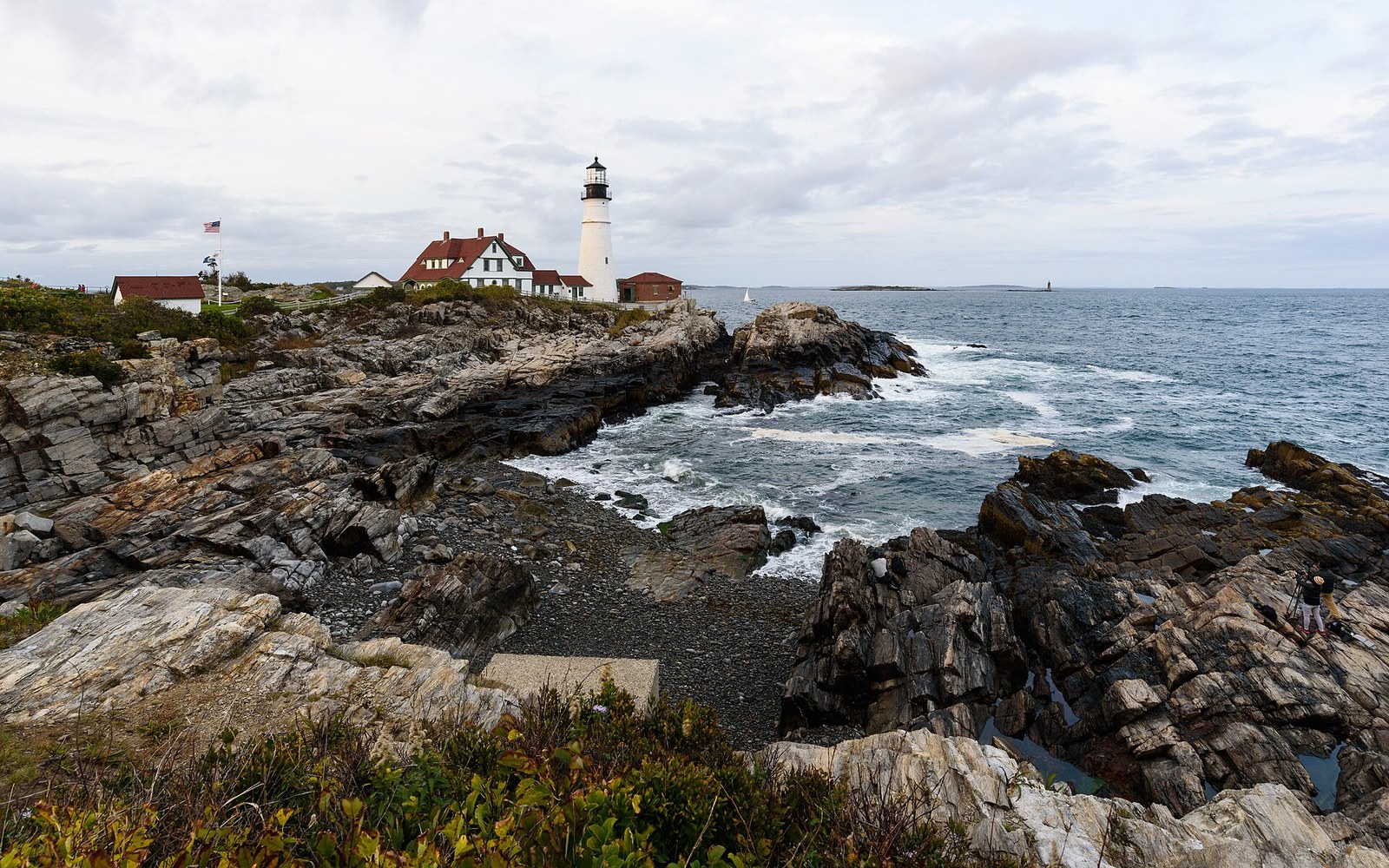 Portland Head Light above a rocky Atlantic shoreline.